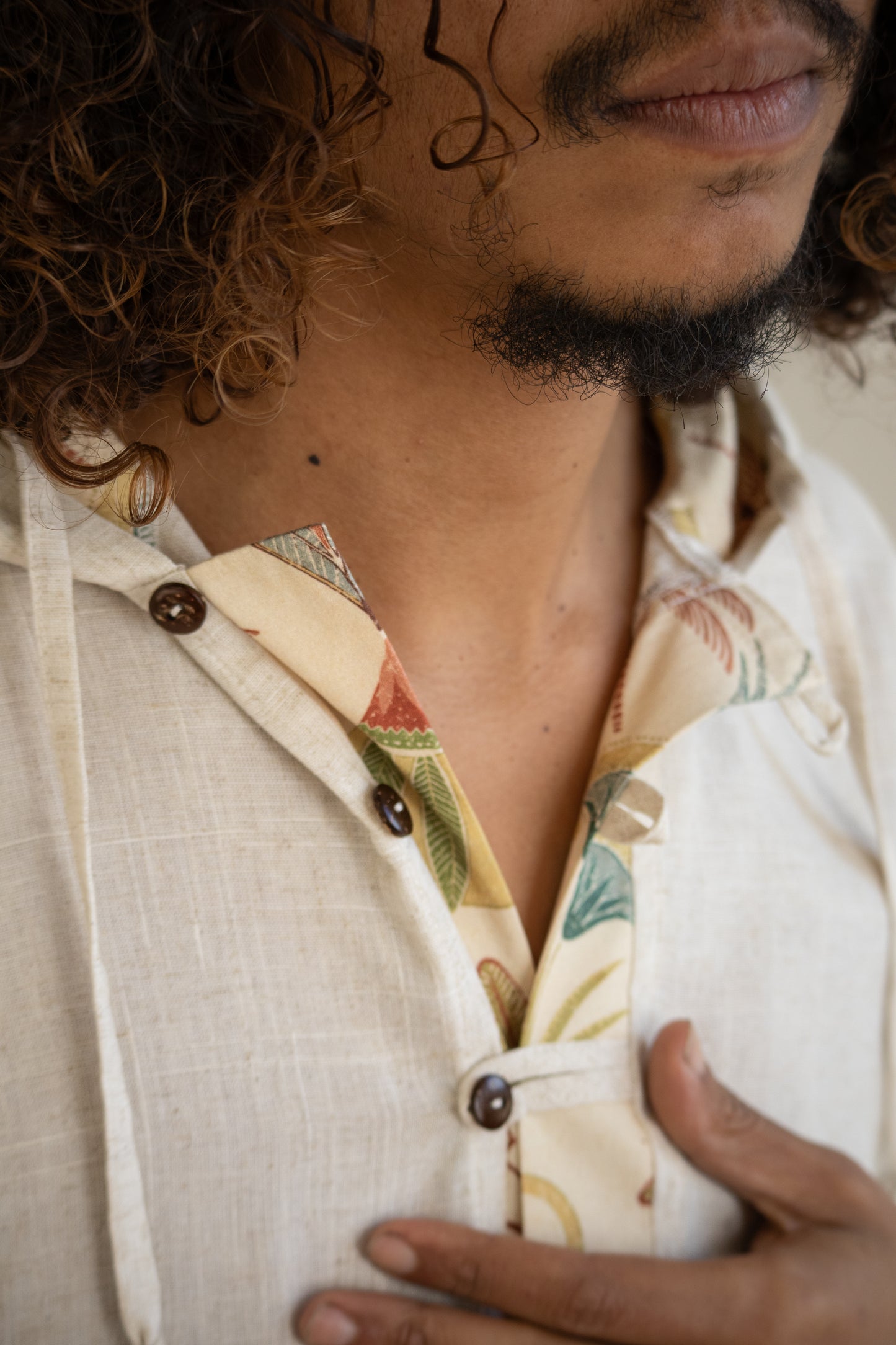 Close-up of a person wearing a patterned shirt with a neutral background
