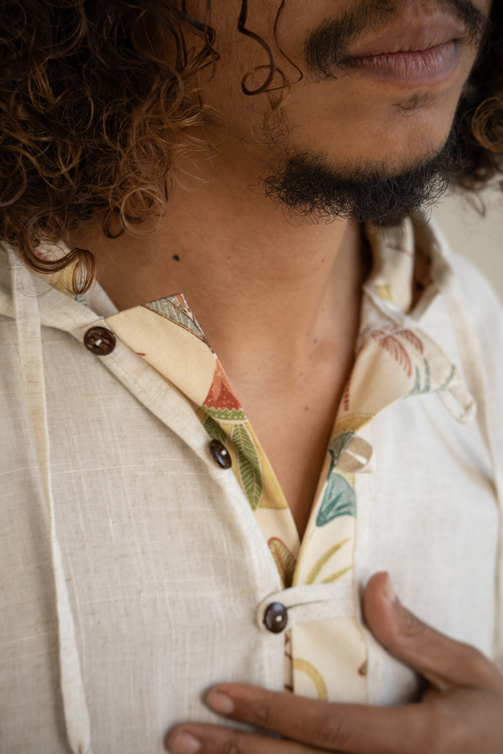 Close-up of a person wearing a patterned shirt with a neutral background